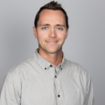 A headshot of a man in his 30s
